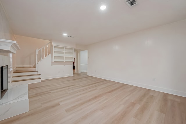 unfurnished living room featuring light hardwood / wood-style flooring and a high end fireplace