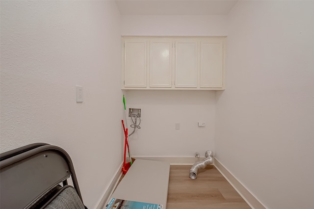 laundry area featuring light hardwood / wood-style floors, washer hookup, and cabinets