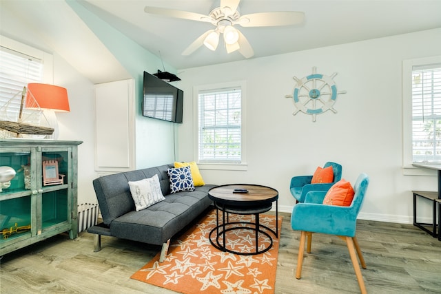 sitting room with ceiling fan, radiator heating unit, vaulted ceiling, and hardwood / wood-style flooring