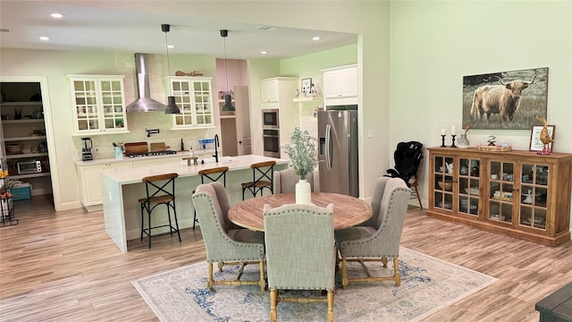 dining area with light wood-type flooring and sink