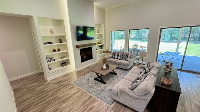 living room with crown molding, a high ceiling, and hardwood / wood-style flooring