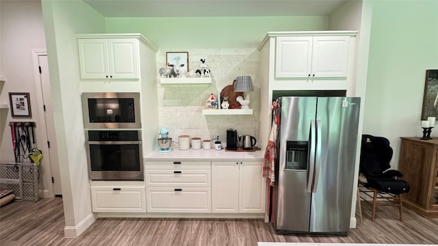 bar with white cabinets, stainless steel appliances, and light hardwood / wood-style floors