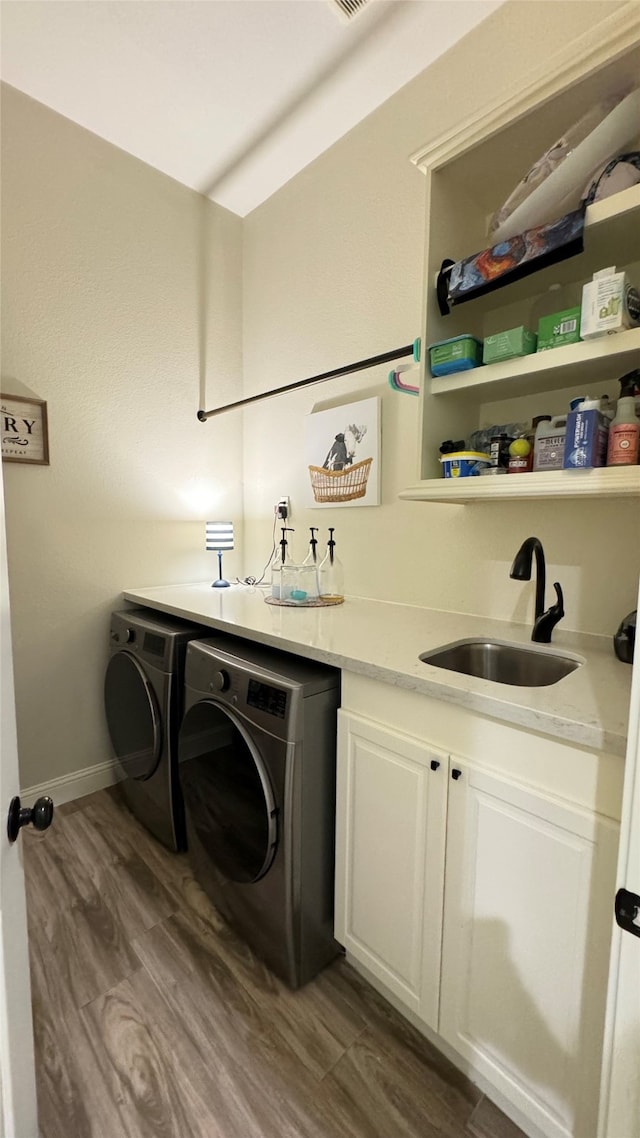 laundry room with indoor wet bar, dark hardwood / wood-style flooring, cabinets, and washer and dryer