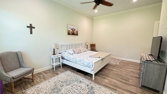 bedroom with crown molding, ceiling fan, and hardwood / wood-style floors