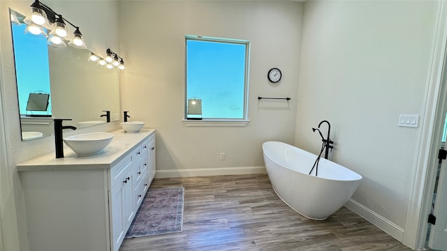 bathroom featuring a tub to relax in, hardwood / wood-style flooring, and vanity