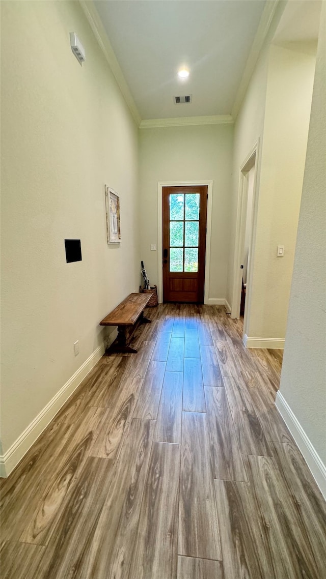 doorway to outside featuring crown molding and light hardwood / wood-style floors