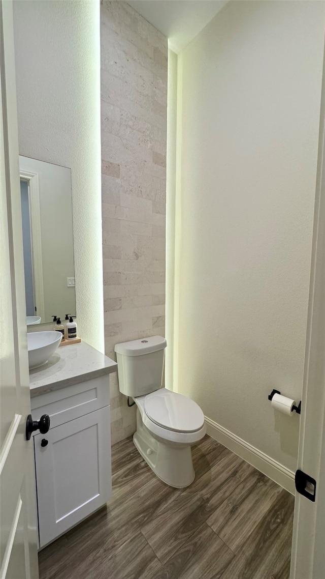 bathroom with vanity, toilet, and hardwood / wood-style flooring