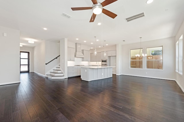 unfurnished living room featuring plenty of natural light and dark hardwood / wood-style floors