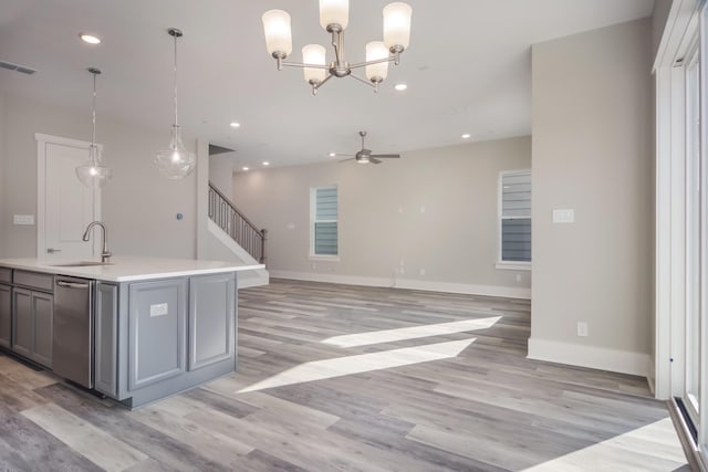 kitchen with light hardwood / wood-style floors, hanging light fixtures, and sink