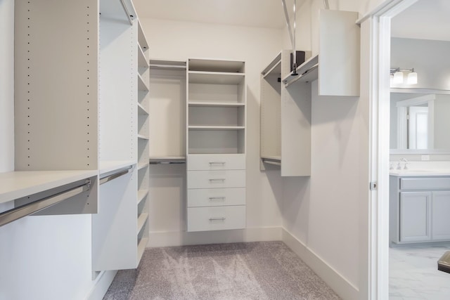 walk in closet with light carpet and sink