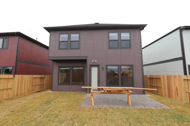 back of house featuring a patio area and a lawn