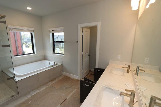 bathroom with vanity and shower with separate bathtub