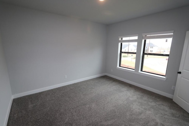 unfurnished room featuring dark colored carpet