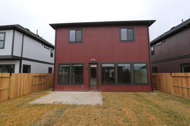 rear view of house featuring a yard and a patio