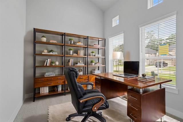 office with a wealth of natural light, light colored carpet, and high vaulted ceiling