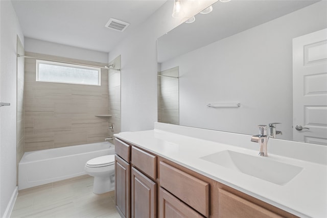 full bathroom featuring vanity, tiled shower / bath combo, and toilet