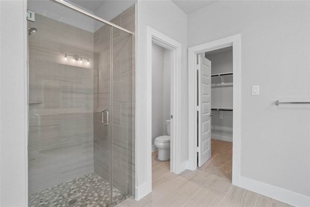 bathroom featuring a shower with door, tile patterned floors, and toilet