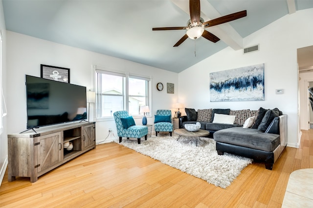 living room featuring ceiling fan, light wood-type flooring, and vaulted ceiling with beams