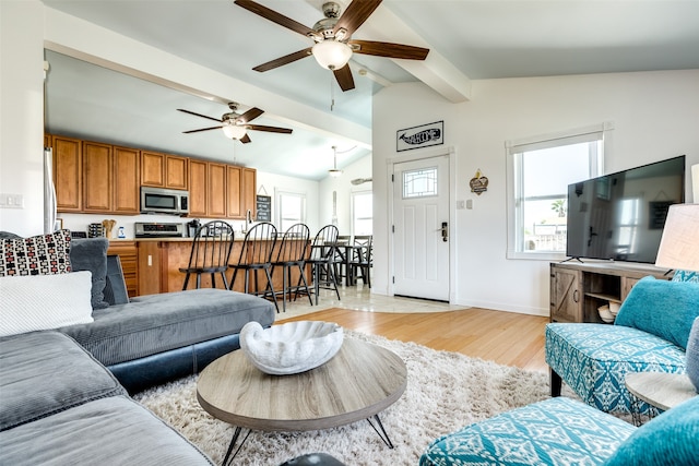 living room featuring ceiling fan, vaulted ceiling with beams, and light hardwood / wood-style flooring