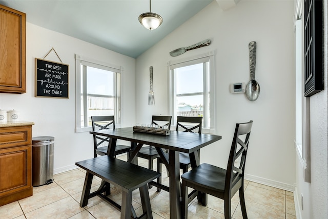 tiled dining area featuring lofted ceiling