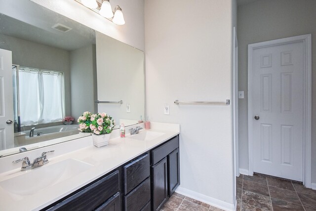 full bath with double vanity, visible vents, baseboards, and a sink