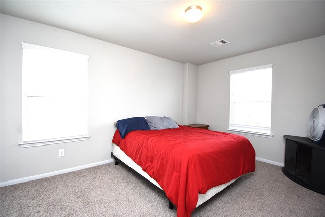 carpeted bedroom featuring visible vents and baseboards