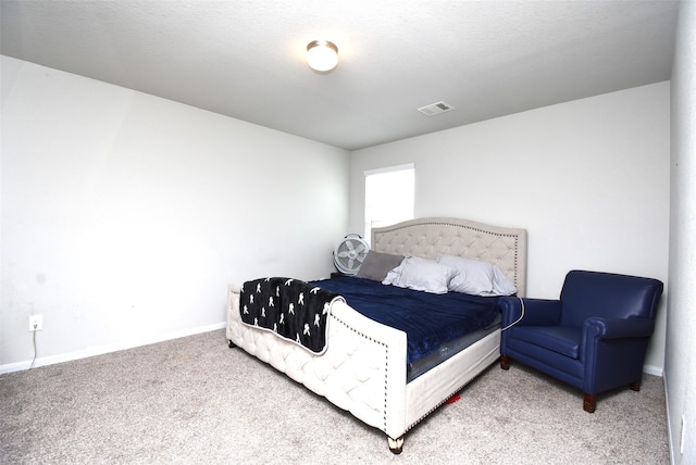 bedroom featuring a textured ceiling and carpet flooring