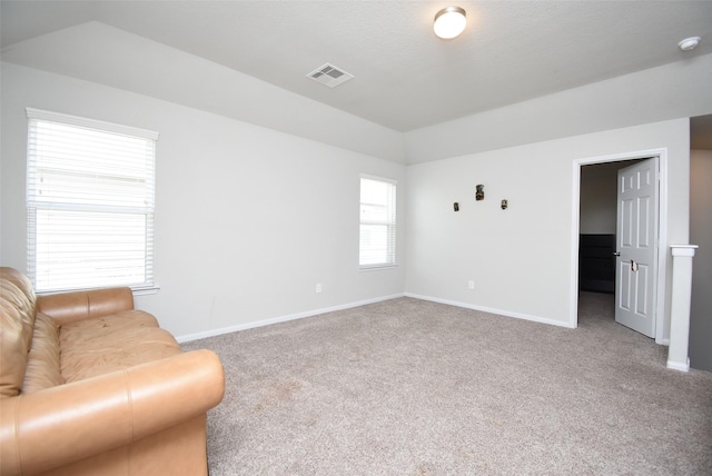 living room featuring vaulted ceiling, carpet flooring, baseboards, and visible vents
