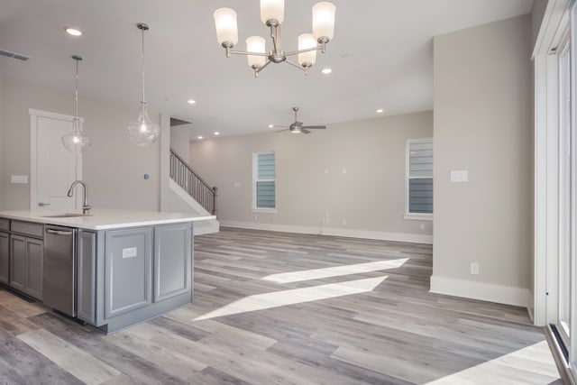 kitchen featuring sink, decorative light fixtures, and light hardwood / wood-style flooring