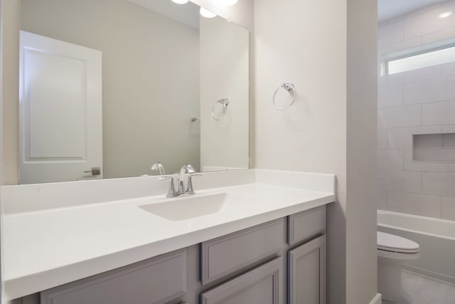 full bathroom featuring vanity, tiled shower / bath combo, and toilet