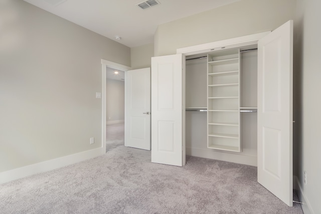 unfurnished bedroom featuring light carpet and a closet