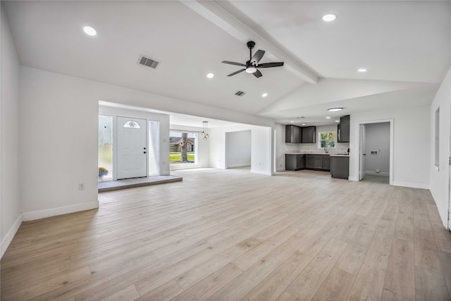 unfurnished living room featuring vaulted ceiling with beams, a healthy amount of sunlight, ceiling fan, and light hardwood / wood-style flooring