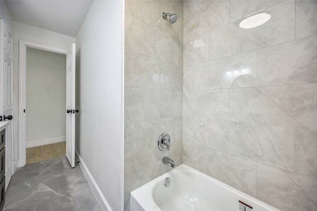 bathroom featuring tiled shower / bath combo and vanity