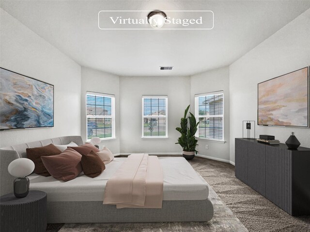 carpeted bedroom featuring multiple windows