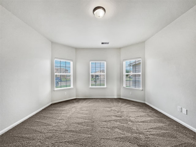 spare room with dark carpet