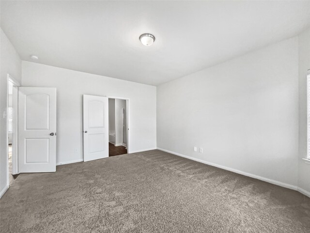 unfurnished bedroom with dark colored carpet