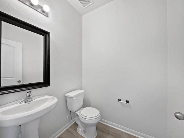 bathroom featuring hardwood / wood-style flooring, sink, and toilet