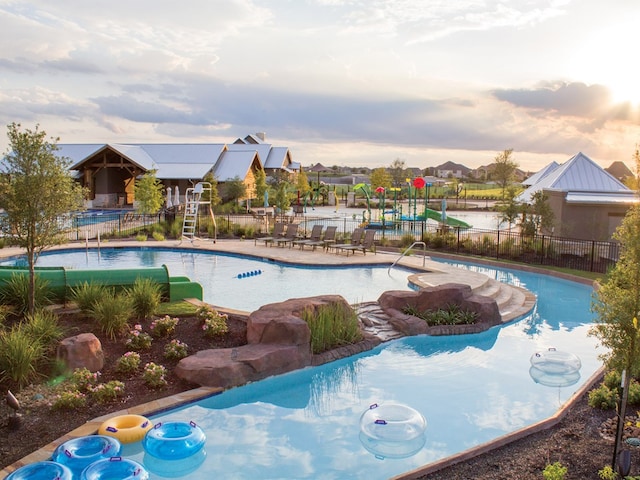 pool at dusk with a patio area