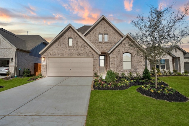 french country home featuring a garage and a lawn