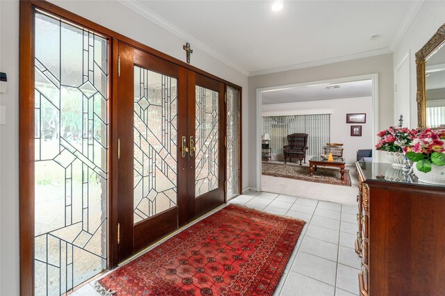 tiled entryway featuring crown molding and french doors