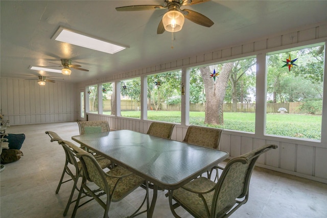 unfurnished sunroom with a skylight, ceiling fan, and a wealth of natural light