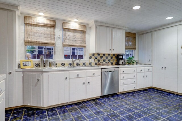 kitchen featuring decorative backsplash, white cabinets, sink, and stainless steel dishwasher