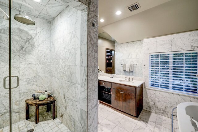 bathroom featuring tile walls, vaulted ceiling, independent shower and bath, and vanity