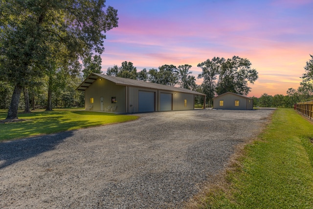 ranch-style home with an outbuilding and a lawn