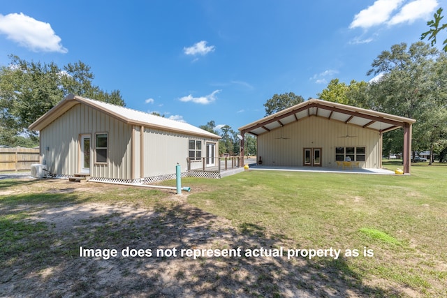 back of house featuring a lawn and a patio