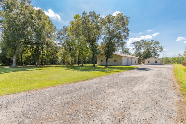 view of front of house featuring an outdoor structure, a garage, and a front lawn