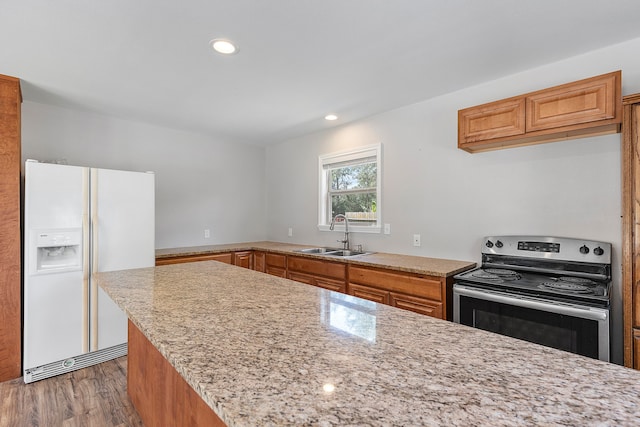 kitchen featuring white refrigerator with ice dispenser, light stone countertops, light hardwood / wood-style flooring, sink, and electric stove