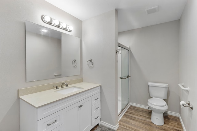 bathroom featuring vanity, toilet, hardwood / wood-style floors, and walk in shower