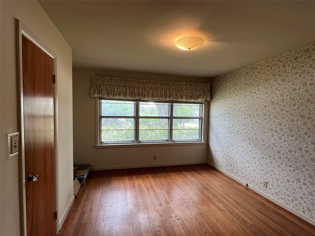 unfurnished room with wood-type flooring