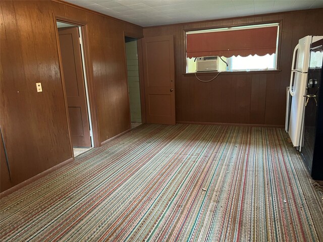 entrance foyer featuring cooling unit, wood walls, and light carpet